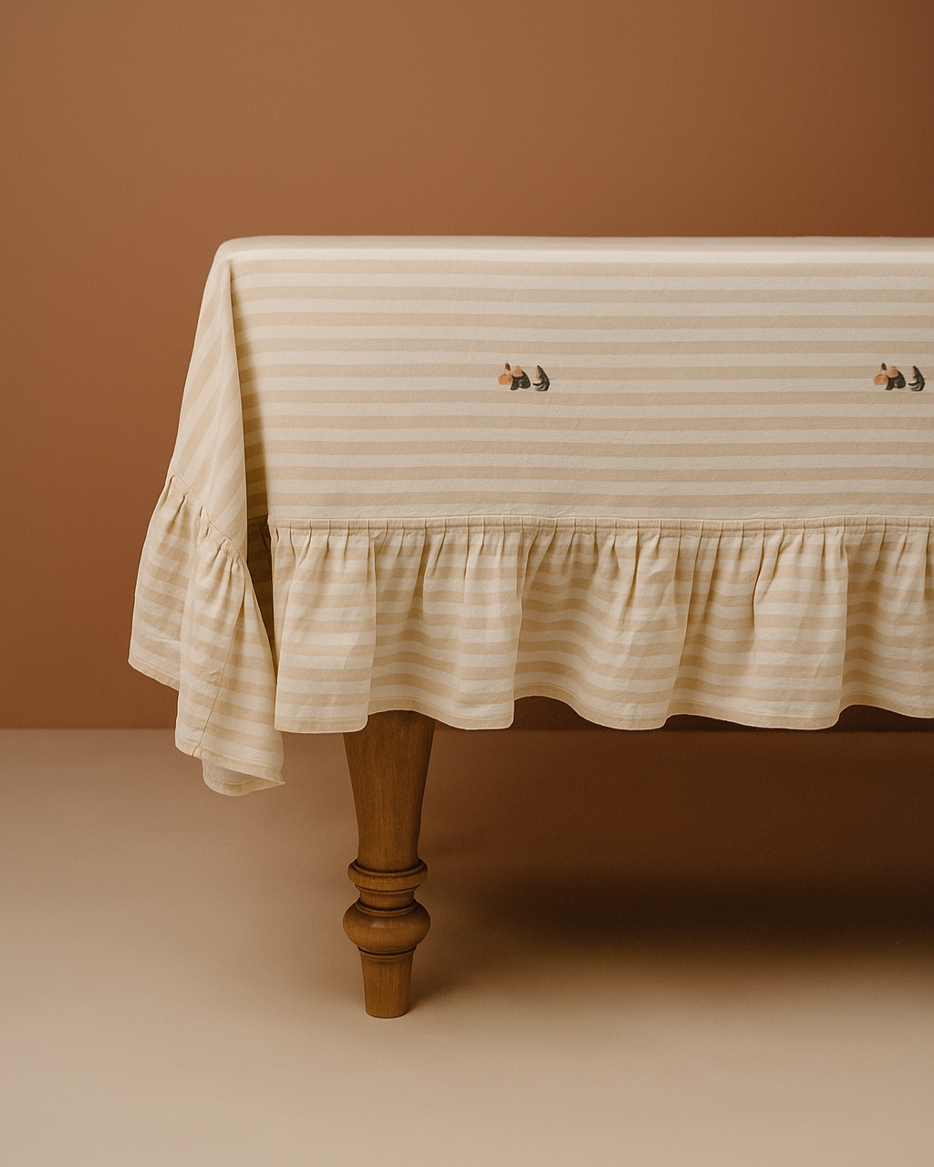 Striped tablecloth with ruffled edge on a wooden table against a brown background